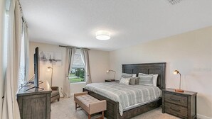 A bedroom with a large bed, bedside tables, a bench, and a desk with a computer. - You Will Love This 5 Star Villa Located on Storey Lake Resort, Orlando Villa 5492 (Kissimmee)