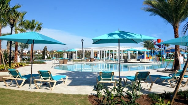 A pool area with lounge chairs and umbrellas, surrounded by palm trees and a gazebo. - You Have Found the Ultimate Luxury 6 Bedroom Villa on Windsor at Westside Resort, Orlando Villa 5035 (Kissimmee)