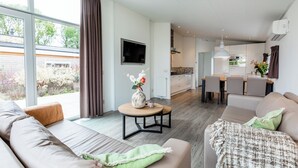 Ein modernes Wohnzimmer mit einer Couch, einem Couchtisch und Blick auf die Küche.