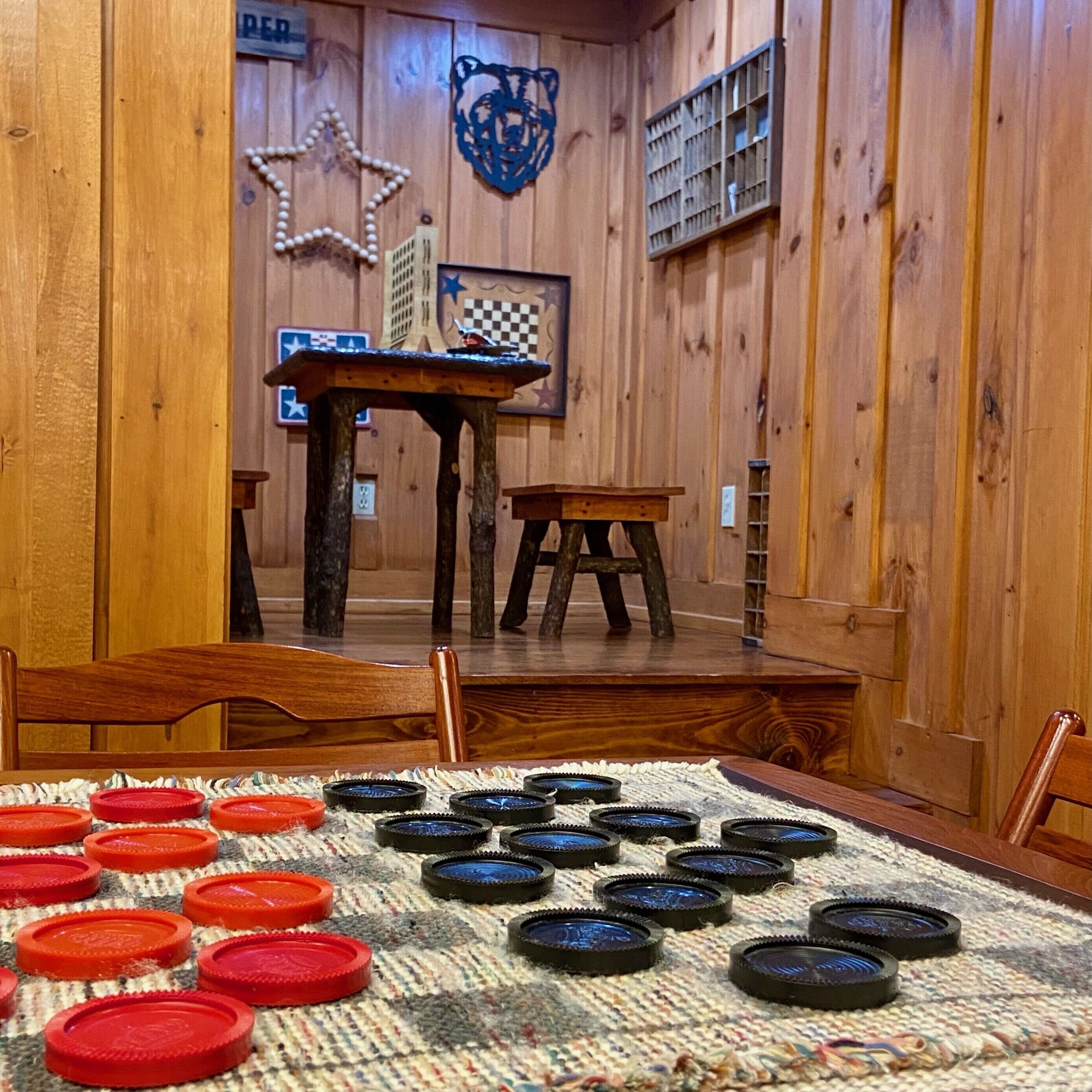 A room with wooden walls, a table with a checkered tablecloth, and a star decoration on the wall.