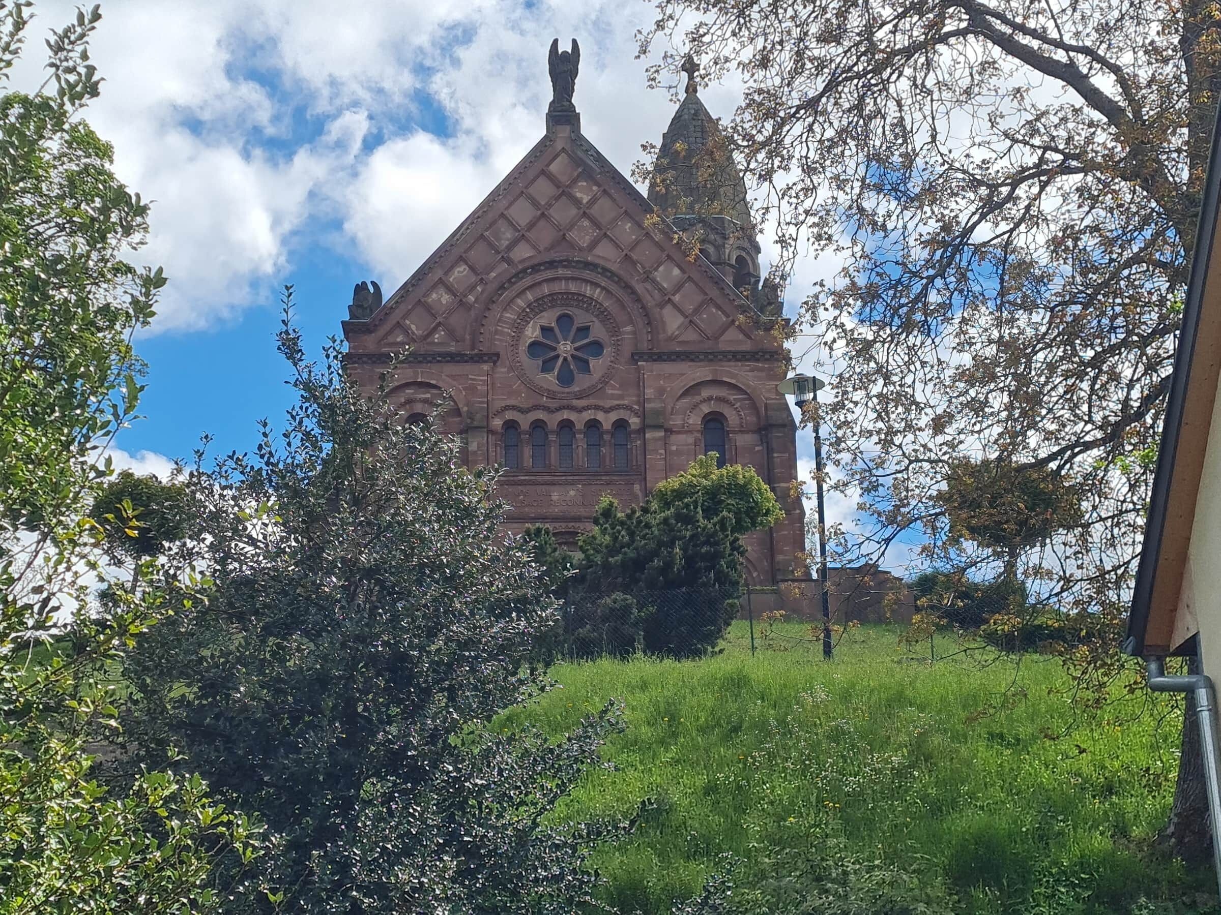A historic building with a prominent rose window and a tall spire.