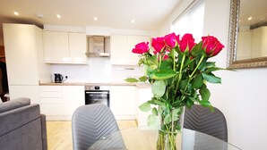 A modern kitchen with white cabinets, a stainless steel oven, and a coffee maker on the counter.