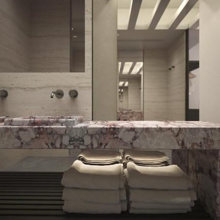 A modern bathroom with a marble sink, towel rack, and a large mirror.