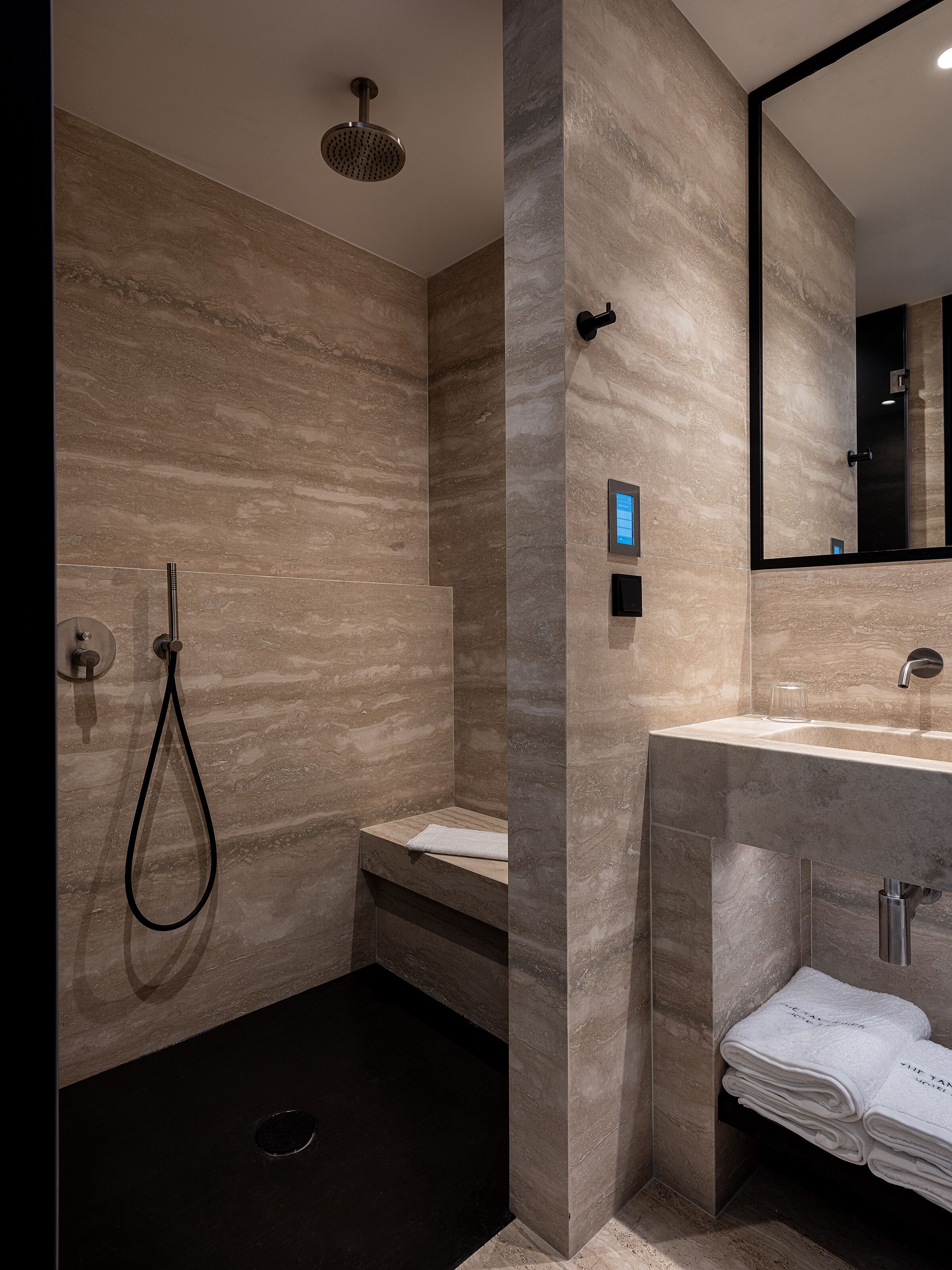 Un baño moderno con ducha, lavamanos y espejo.