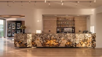 A modern bar area with a marble countertop and a wine display.