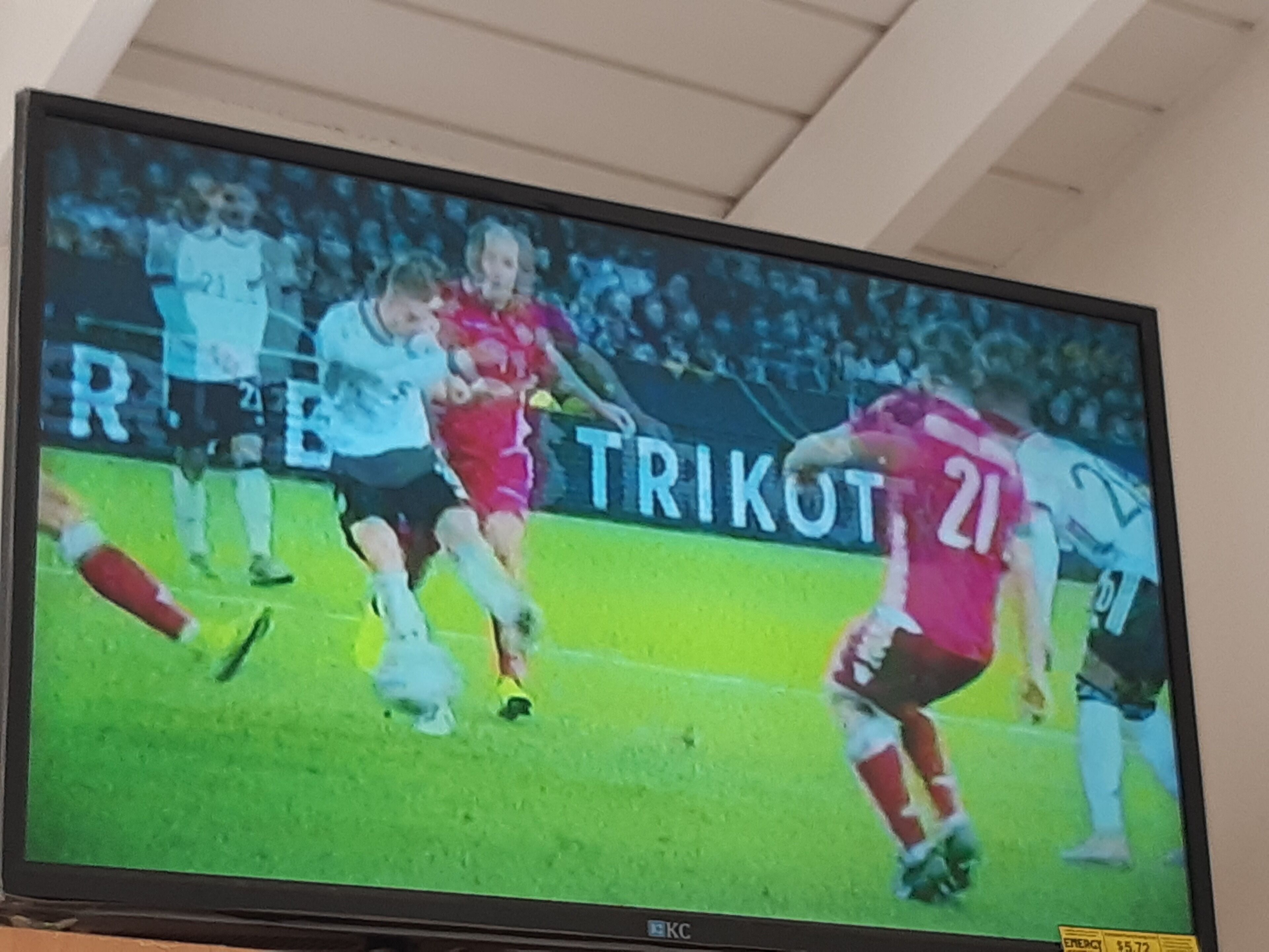 Un televisor mostrando un partido de fútbol.