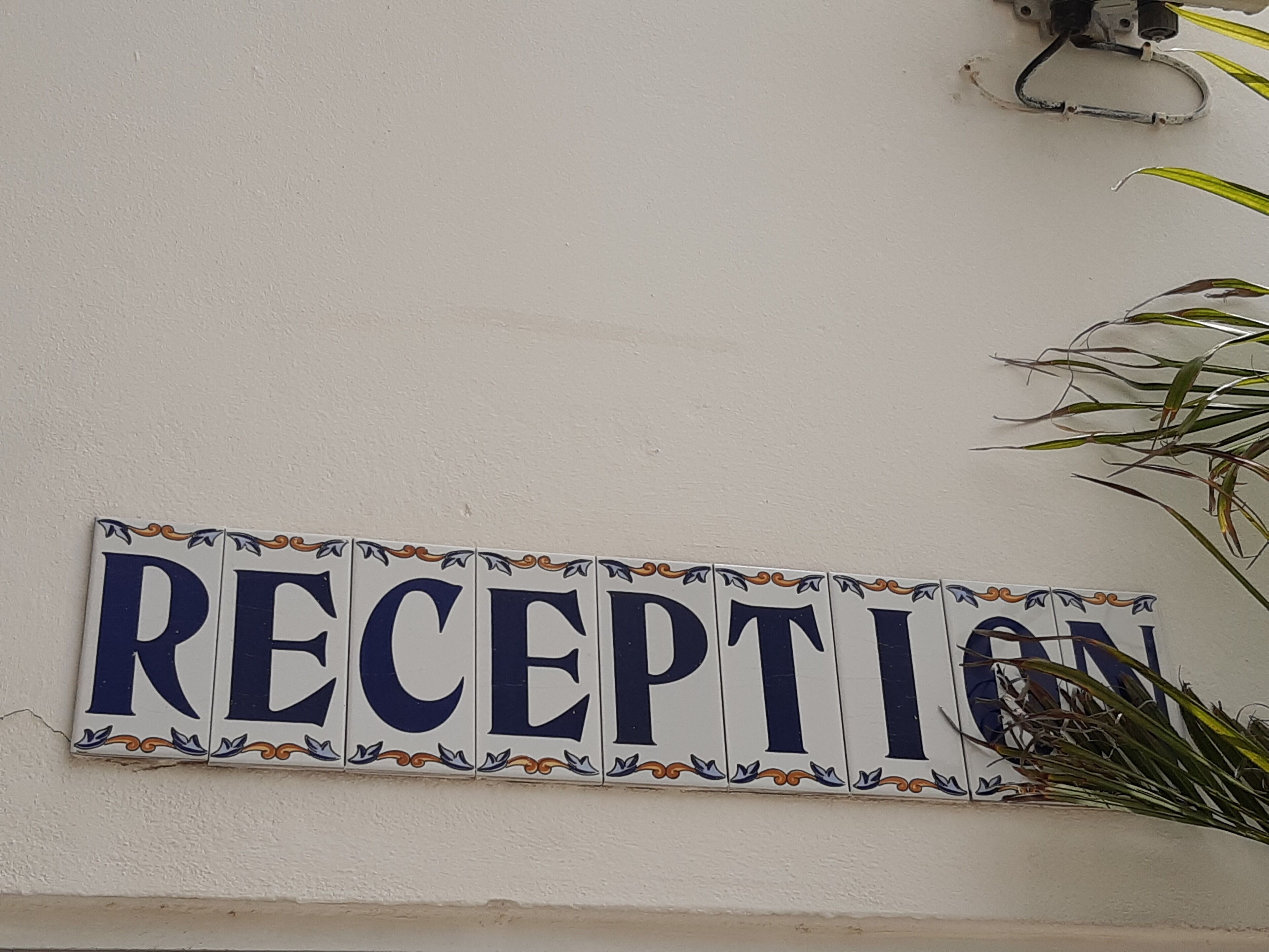 A reception sign with decorative borders on a white wall.