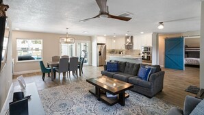 A modern living room with a sofa, coffee table, and dining area. - Waterfront Retreat in the Heart of Tampa. Close to TPA, RayJay and Steinbrenner (Tampa)