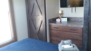 A bedroom with a bed, a wooden wardrobe, a dresser, a mirror, and a television. - Summer Fun in Blue Ridge☀️Mins from Downtown Activities  (Morganton)