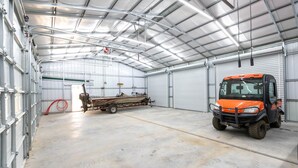 A spacious industrial building with a forklift and a trailer inside.