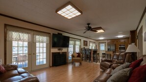 A spacious living room with a fireplace, leather sofas, and a dining area with a table and chairs.