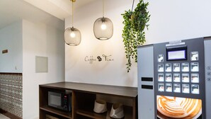 A coffee machine with a digital display and a wall with a 'Coffee Time' sign. - Hostal La Costa (El Ejido)