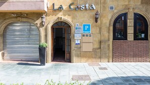 A building with a sign reading "La Costa" and a closed metal shutter on the left. - Hostal La Costa (El Ejido)