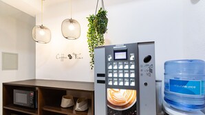 A coffee machine with a digital display, a water dispenser, and a microwave on a counter. - Hostal La Costa (El Ejido)