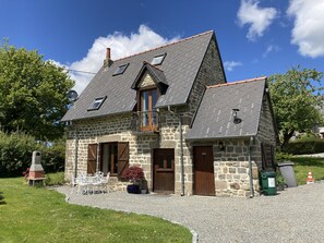 A stone house with a sloped roof, a chimney, and a small balcony. - La Hussaire - The Gingerbread House Cottage (Beauficel)