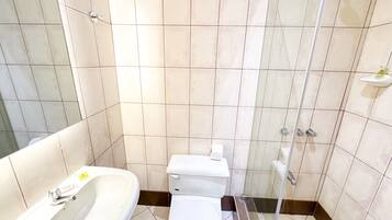 A bathroom with a sink, toilet, and shower.