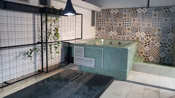 Una cocina moderna con salpicadero de azulejos, una lámpara colgante y un lavamanos empotrado.