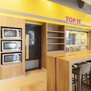 A modern kitchen with built-in microwaves and a wooden counter.