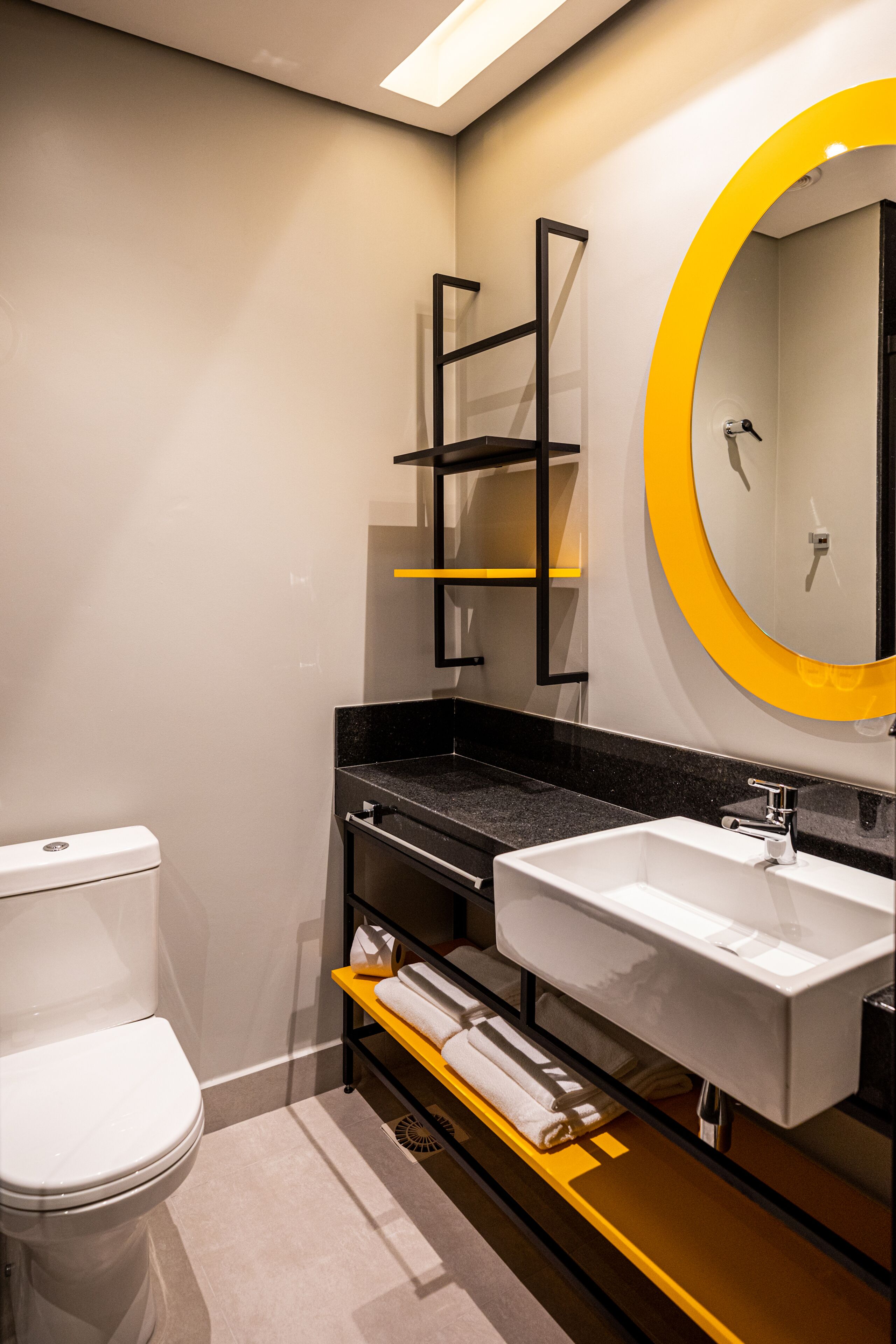 A modern bathroom with a toilet, a sink, and a mirror.