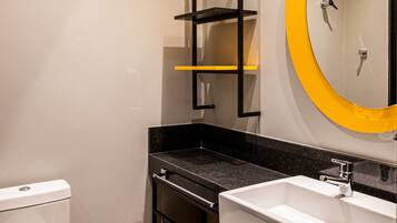 A modern bathroom with a toilet, a sink, and a mirror.
