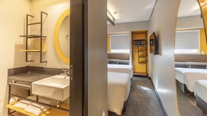 A hotel room with a modern bathroom, a bed, a wardrobe, and a mirror. - Tru By Hilton Criciúma (Criciuma)