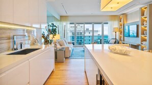 Une chambre d’hôtel moderne dotée d’une cuisine, d’un espace de vie avec vue et d’un balcon.