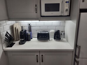 Une cuisine équipée d’un four à micro-ondes, d’un grille-pain, d’une machine à café et d’un bloc à couteaux.