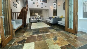 A spacious living area with a staircase, two sofas, a coffee table, and a patterned rug.