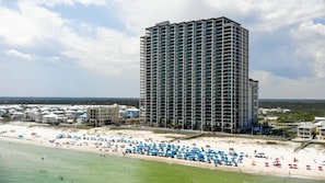 A high-rise hotel with a beach view, multiple balconies, and a beachfront location.