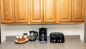Eine Küchenarbeitsfläche mit Kaffeemaschine, Toaster, einer Schachtel Slim Tea und einem Glasbehälter.