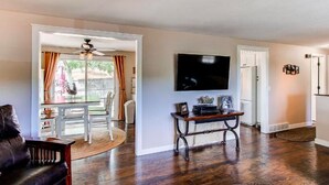A living room with a flat-screen TV, a wooden coffee table, and a leather sofa. - Hidden Valley Retreat. Foothill views. Large Yard! (Loveland)