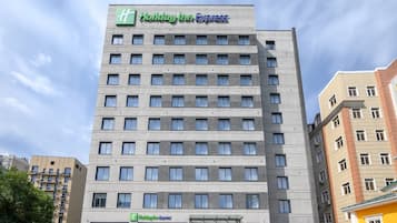 Un hotel Holiday Inn Express con diseño moderno, que presenta un logotipo destacado y una entrada amplia.