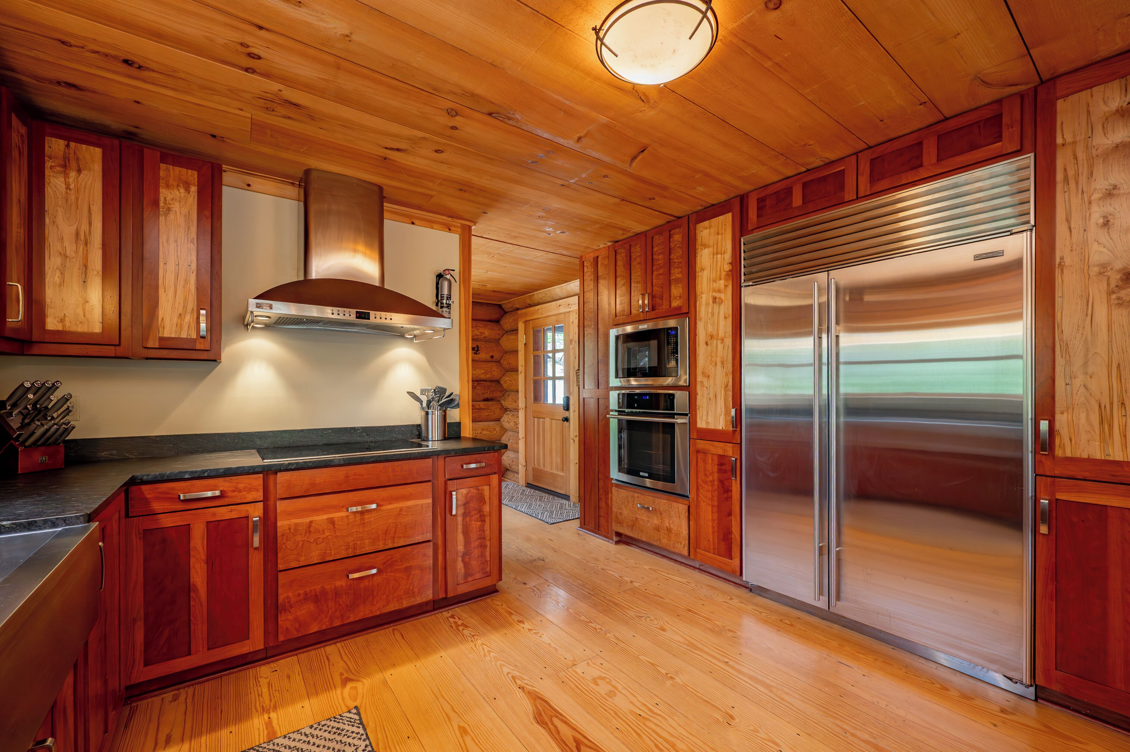 Une cuisine moderne avec des meubles en bois, des appareils en acier inoxydable et un îlot central.