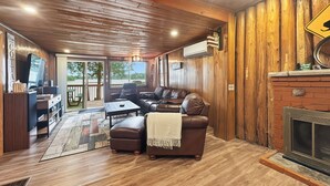 A cozy living room with a fireplace, leather sofa, and a television.