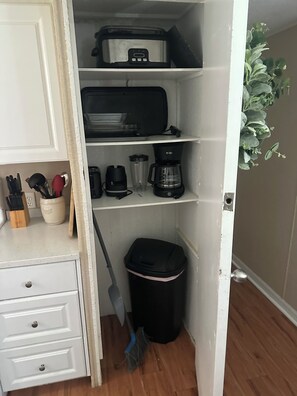 A small kitchen area with a microwave, coffee maker, and a trash bin. - River Retreats/Anglers Paradise (Dunnellon)