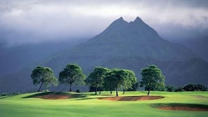 Ein Golfplatz mit einem Berg im Hintergrund.