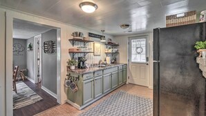 Una cocina con isla central, armarios de madera y un refrigerador negro.