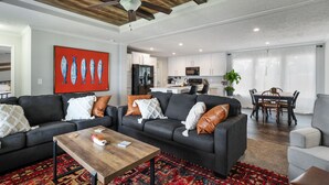 A modern living room with a dark grey sofa, a wooden coffee table, and a red patterned rug. - PJinx and Grace Peaceful Lake front 3BR/2ba (Shelby)
