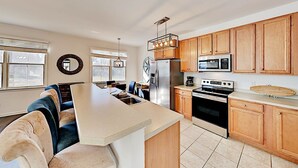 Une cuisine moderne avec des meubles en bois, des appareils en acier inoxydable et un îlot central.