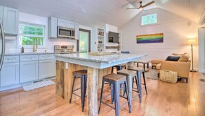 A spacious kitchen with a large island, wooden stools, and a ceiling fan. - Stylish Mountain Home Near Ski, Golf + Manchester! (Bondville)