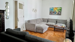 A living room with a gray sectional sofa, a dark armchair, a wooden coffee table, and a painting on the wall. - Charming Villa in the CITY CENTER w/ OUTDOOR PATIO! FREEPARKING (Faro)