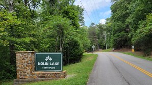 A road leading to Nolin Lake State Park with a stone sign and a grassy area beside the road. - Minutes from Mammoth Cave and Nolin Lake! (Mammoth Cave)