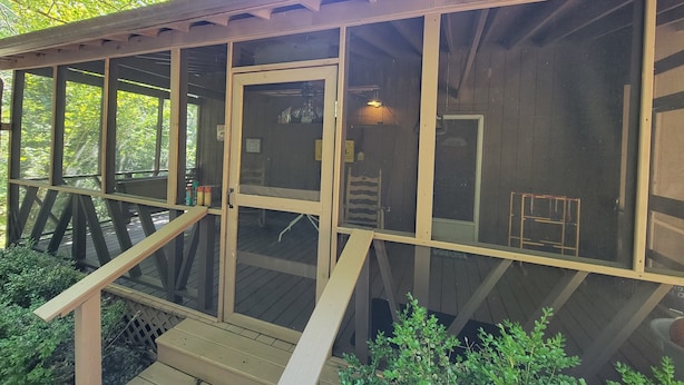 A wooden deck with a glass door leading to an interior room, surrounded by greenery. - Minutes from Mammoth Cave and Nolin Lake! (Mammoth Cave)