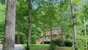 A rustic building surrounded by a forested area with a gravel path leading to it. - Minutes from Mammoth Cave and Nolin Lake! (Mammoth Cave)