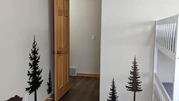 Cozy space with a crib and door leading to another area.