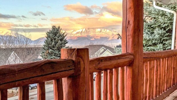 A wooden deck with a view of a snowy mountain range.