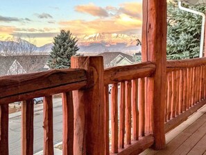 Eine Holzterrasse mit Blick auf ein verschneites Gebirge.