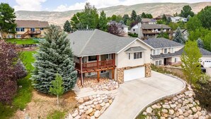 A residential area with a house featuring a stone foundation, a covered porch, and a garage.