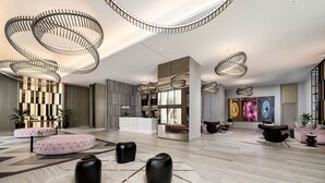 Eine großzügige Lobby mit einer zentralen Rezeption, Sitzbereichen und modernen Leuchten.