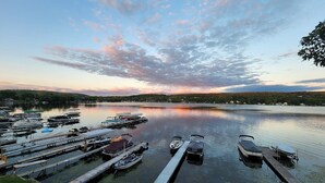 Un port de plaisance avec des bateaux amarrés, une eau calme et un coucher de soleil en arrière-plan.